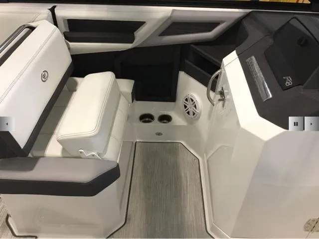 Slide: The Image of 2024 Cobalt R8 boat interior with white seating, cup holders, and modern dashboard. - 10