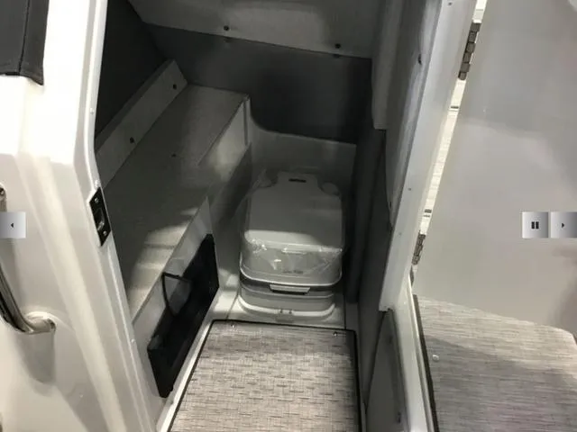 Slide: The Image of 2024 Cobalt R8 boat interior with compact toilet and storage area. - 13