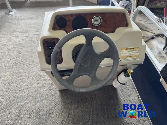 Slide: The Image of 2012 Weeres Cadet 200 Pontoon steering console with gauges and warning label. - 24