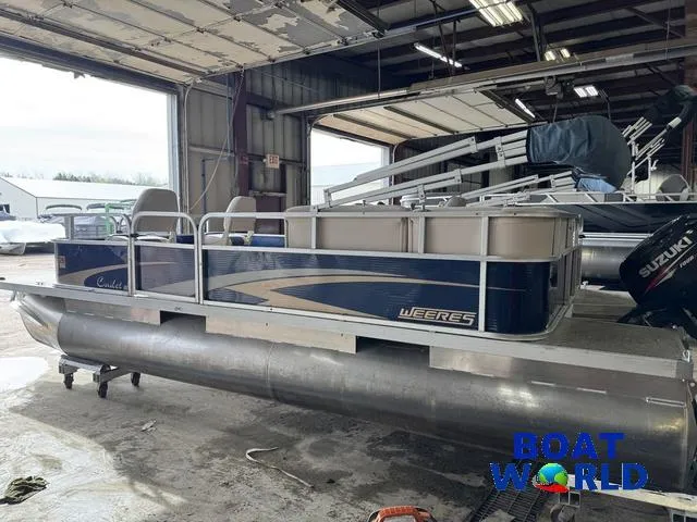 Slide: The Image of 2012 Weeres Cadet 200 Pontoon boat in a warehouse, featuring blue and silver design. - 34