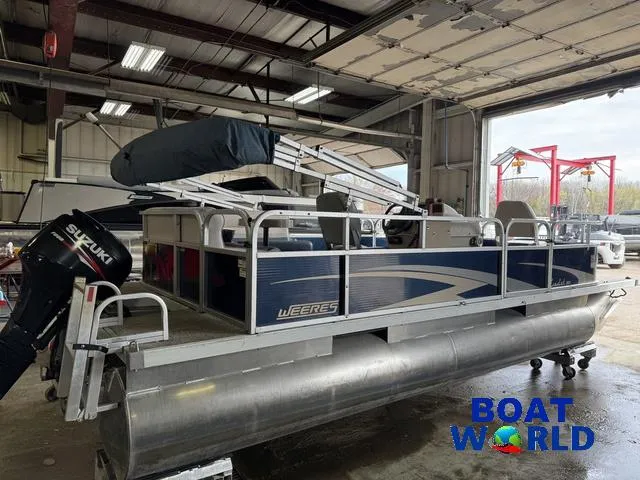 Slide: The Image of 2012 Weeres Cadet 200 Pontoon boat in a garage with Suzuki outboard motor. - 38
