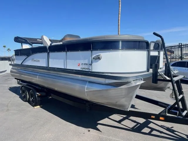 Slide: The Image of 2021 Manitou 23 Aurora LE VP pontoon boat on trailer, parked outdoors. - 4