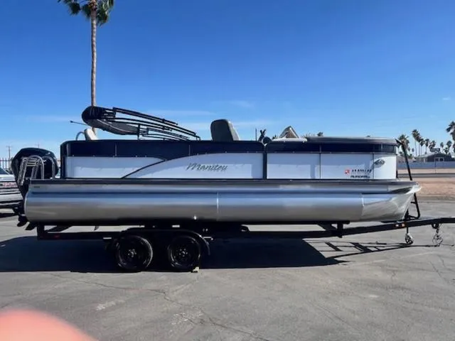 Slide: The Image of 2021 Manitou 23 Aurora LE VP pontoon boat on trailer, parked outdoors under clear blue sky. - 5