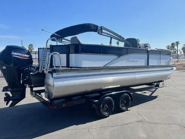 Slide: The Image of 2021 Manitou 23 Aurora LE VP pontoon boat on trailer, featuring Mercury outboard motor. - 6