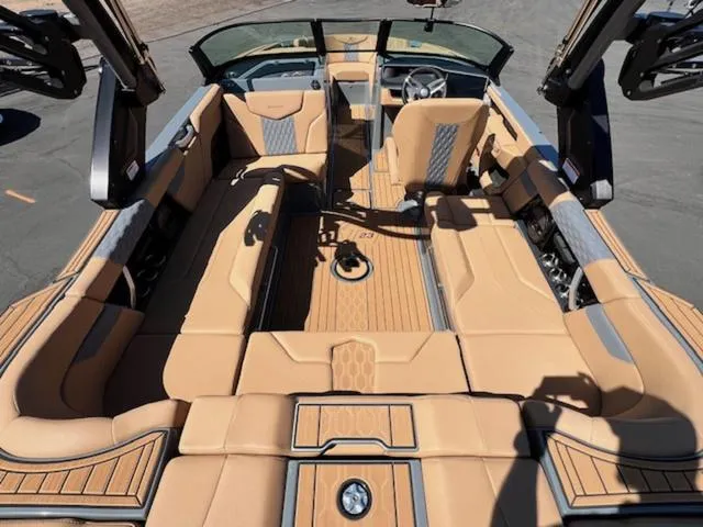 Slide: The Image of 2025 MasterCraft XT23 boat interior with tan upholstery and sleek design. - 11