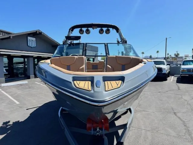 Slide: The Image of 2025 MasterCraft XT23 boat with sleek design, parked outdoors under clear blue sky. - 3