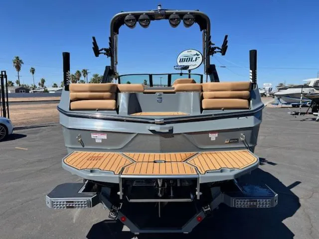 Slide: The Image of 2025 MasterCraft XT23 boat with tan seating and sleek design, parked outdoors. - 7