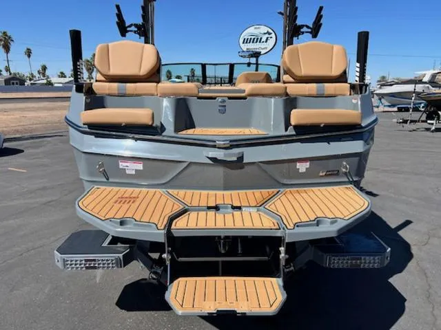 Slide: The Image of 2025 MasterCraft XT23 boat with tan seating and teak swim platform. - 9