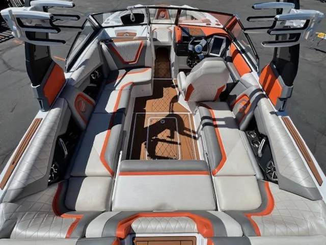 Slide: The Image of 2017 Tigé RZX2 boat interior with orange and gray upholstery, spacious seating, and modern dashboard. - 10