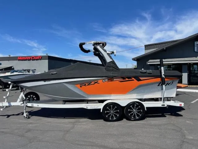 Slide: The Image of 2017 Tigé RZX2 boat on trailer, parked outside dealership under clear blue sky. - 20