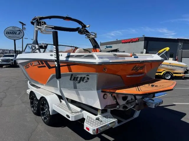 Slide: The Image of 2017 Tigé RZX2 boat with orange and white design on a trailer, parked outdoors. - 8