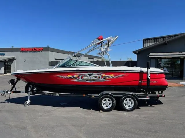 Slide: The Image of 2006 MasterCraft X30 boat in red with custom graphics on a trailer. - 1