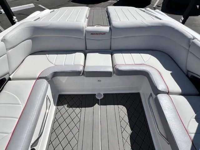 Slide: The Image of 2006 MasterCraft X30 boat interior with white cushioned seating and gray flooring. - 16