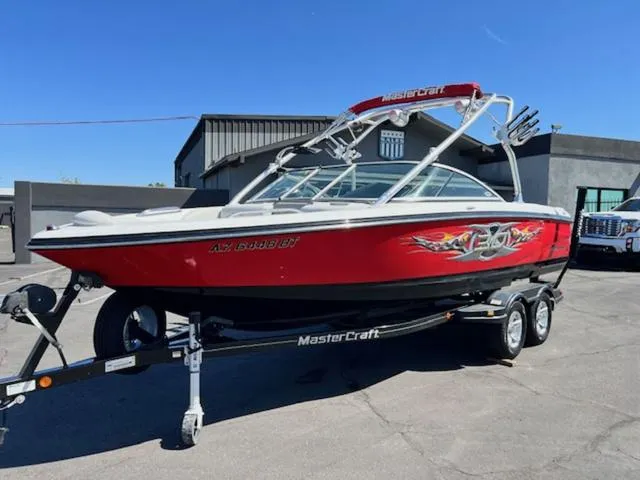 Slide: The Image of 2006 MasterCraft X30 boat with red exterior and custom graphics on a trailer. - 2
