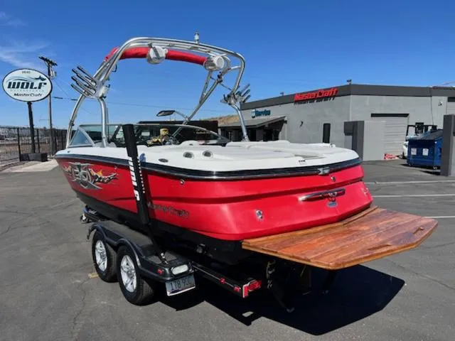 Slide: The Image of 2006 MasterCraft X30 boat in red, parked on a trailer at a dealership. - 8