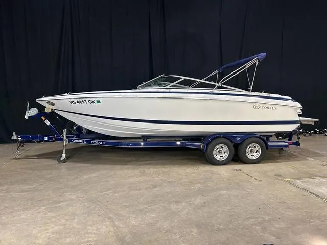 Slide: The Image of 2003 Cobalt 226 boat on trailer, white with blue accents, displayed indoors. - 1