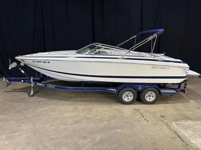 Slide: The Image of 2003 Cobalt 226 boat on trailer, white with blue accents, indoor display. - 11