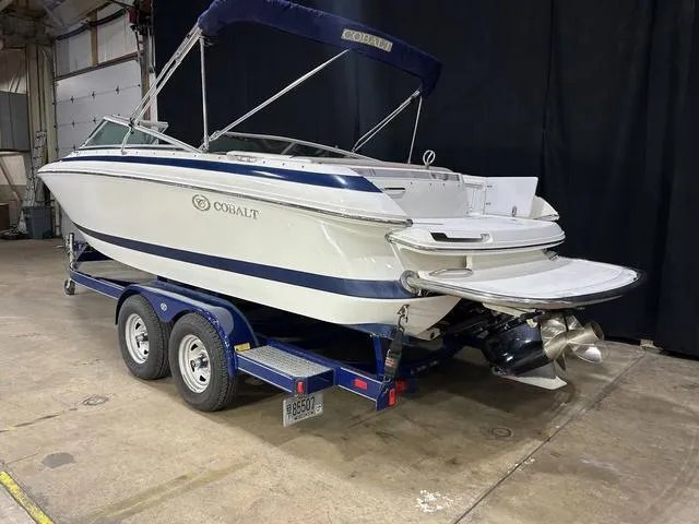 Slide: The Image of 2003 Cobalt 226 boat on trailer in indoor setting, featuring blue and white design. - 16
