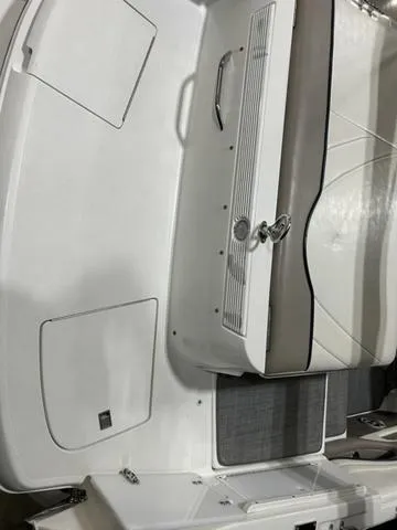 Slide: The Image of 2003 Cobalt 226 boat interior with white seating and storage compartments. - 19