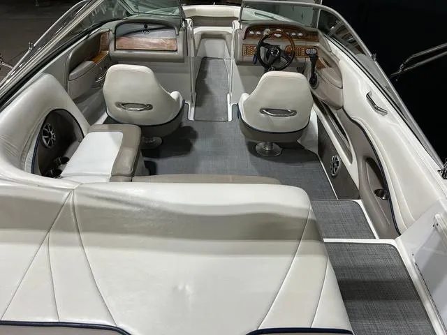 Slide: The Image of 2003 Cobalt 226 boat interior with white seating and wood-accented dashboard. - 22