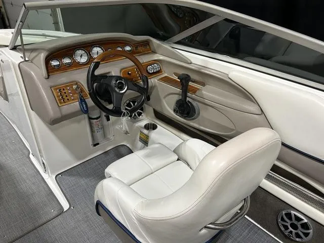 Slide: The Image of Interior of a 2003 Cobalt 226 boat with white seating and wooden dashboard. - 23