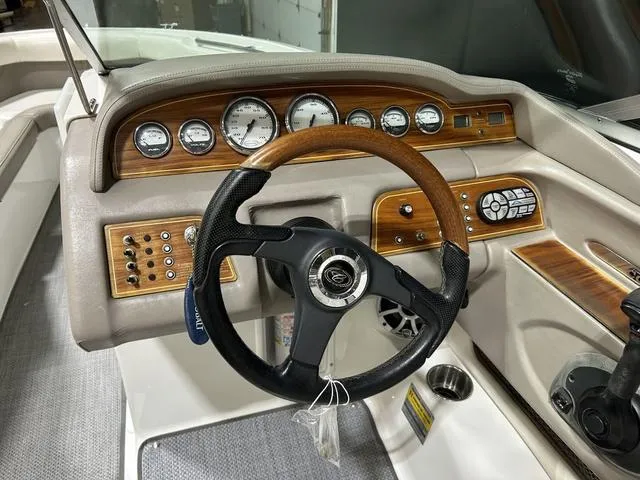 Slide: The Image of 2003 Cobalt 226 boat dashboard with wood accents and steering wheel. - 24