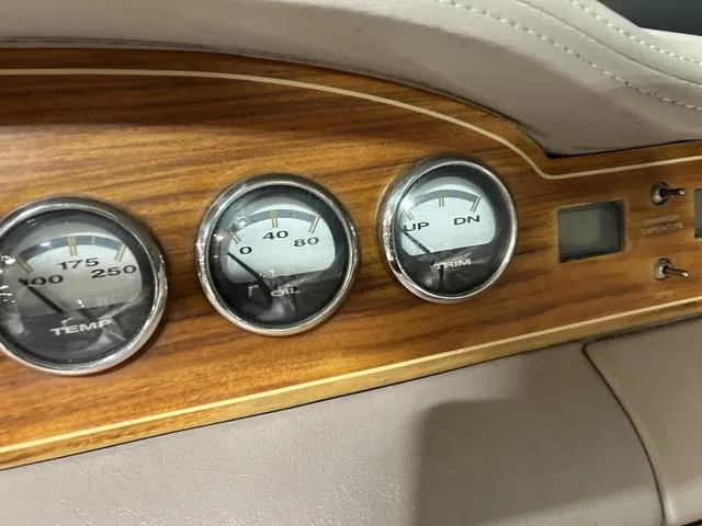Slide: The Image of Dashboard gauges of a 2003 Cobalt 226 boat with wood paneling. - 4