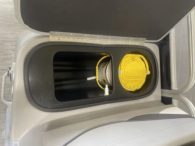 Slide: The Image of Storage compartment in a 2023 Bennington 20 SVF boat with yellow lid. - 23