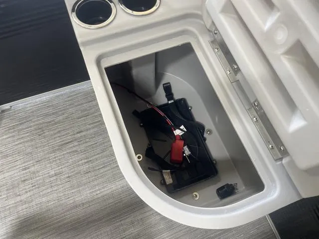 Slide: The Image of Open storage compartment in 2023 Bennington 20 SVF boat, showing wiring and cup holders. - 25