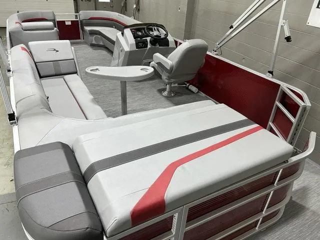 Slide: The Image of 2023 Bennington 24 SXL pontoon boat interior with gray and red seating and steering console. - 10