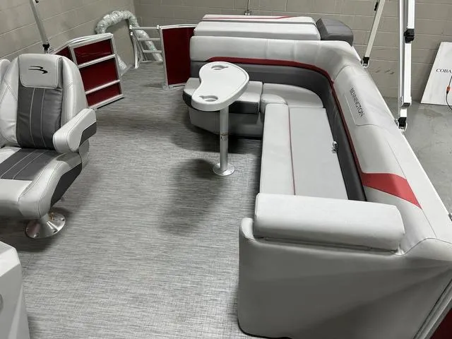 Slide: The Image of 2023 Bennington 24 SXL pontoon boat interior with gray and red seating and table. - 23