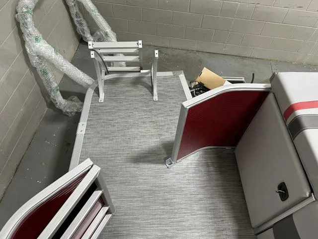 Slide: The Image of 2023 Bennington 24 SXL pontoon boat interior with red accents and seating. - 24