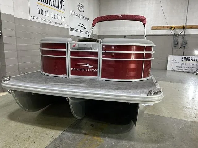 Slide: The Image of 2023 Bennington 24 SXL pontoon boat in showroom, featuring red exterior and sleek design. - 4