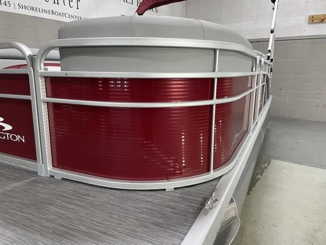 Slide: The Image of 2023 Bennington 20 SVL pontoon boat with red and silver exterior in a showroom. - 4