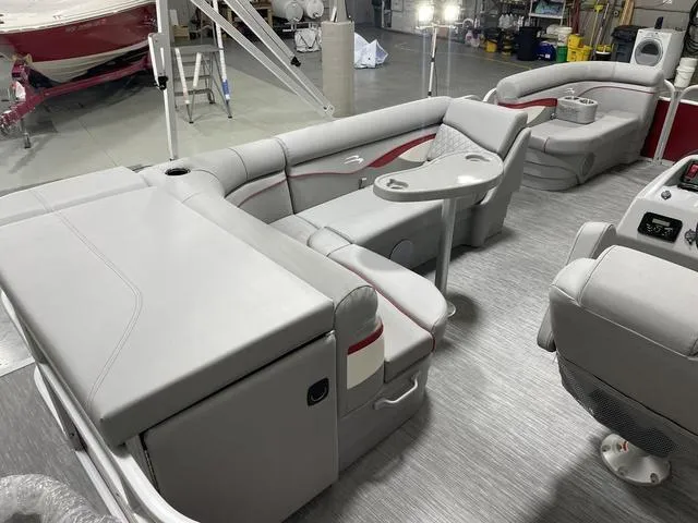 Slide: The Image of 2023 Bennington 20 SVL pontoon boat interior with gray seating and table in a showroom. - 8
