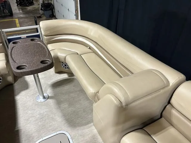 Slide: The Image of 2016 Bennington 2550 GSR boat interior with beige seating and a table. - 10