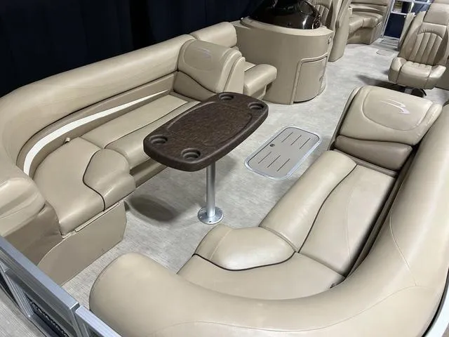 Slide: The Image of 2016 Bennington 2550 GSR pontoon boat interior with beige seating and a central table. - 21