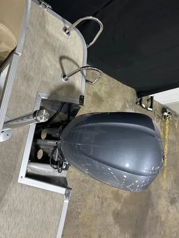 Slide: The Image of 2016 Bennington 2550 GSR boat with outboard motor, viewed from above in a garage setting. - 26