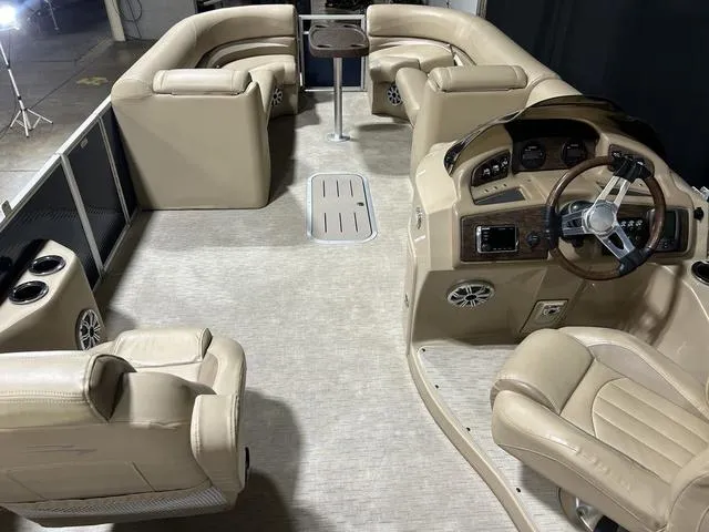 Slide: The Image of 2016 Bennington 2550 GSR pontoon boat interior with beige seating and steering console. - 8