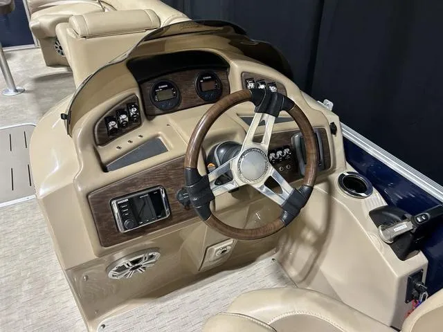 Slide: The Image of 2016 Bennington 2550 GSR boat dashboard with wood-accented steering wheel and control panel. - 9