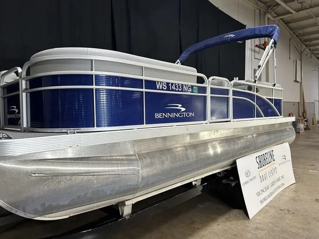 Slide: The Image of 2022 Bennington 22 SVSR pontoon boat displayed indoors with blue and silver design. - 3