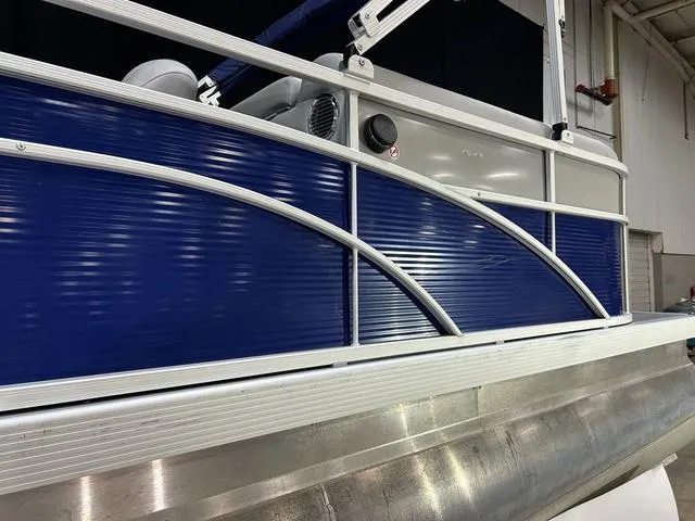 Slide: The Image of 2022 Bennington 22 SVSR pontoon boat with blue and silver detailing in a showroom. - 8