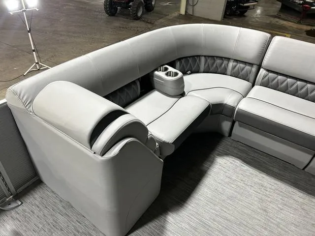 Slide: The Image of Luxurious seating on 2022 Bennington 24 LXSB boat, featuring plush gray upholstery and cup holders. - 12
