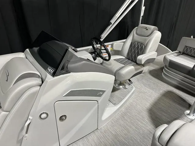 Slide: The Image of 2022 Bennington 24 LXSB boat interior with sleek gray seating and modern dashboard. - 13