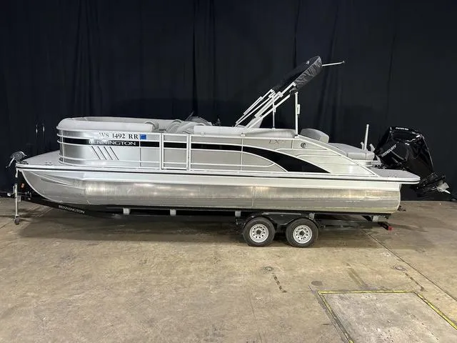 Slide: The Image of 2022 Bennington 24 LXSB pontoon boat on trailer, displayed indoors. - 15