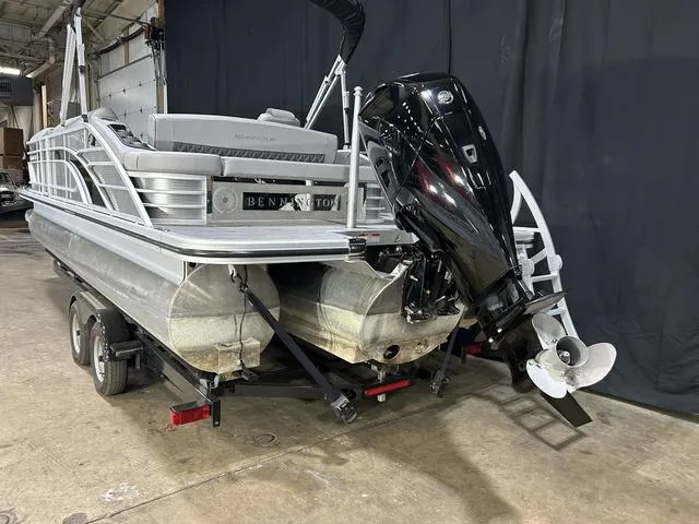 Slide: The Image of 2022 Bennington 24 LXSB pontoon boat on trailer, featuring a powerful outboard motor. - 19