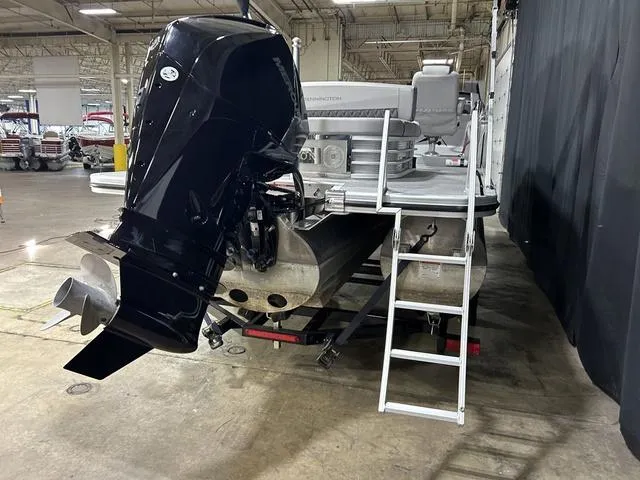 Slide: The Image of 2022 Bennington 24 LXSB pontoon boat with outboard motor in a warehouse setting. - 3