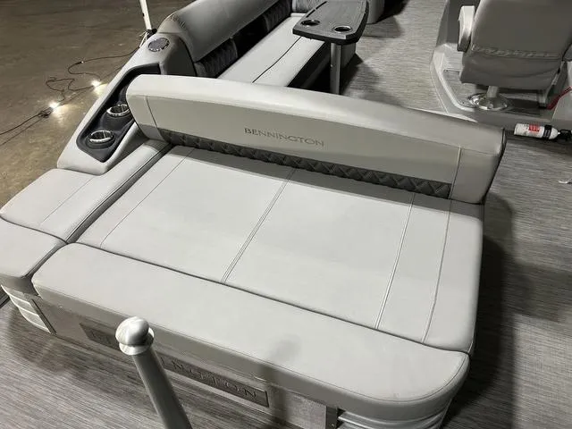Slide: The Image of 2022 Bennington 24 LXSB boat interior with gray seating and cup holders. - 5