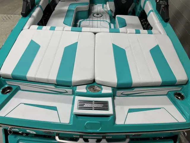 Slide: The Image of 2023 Malibu 21 LX boat interior with teal and white seating design. - 11