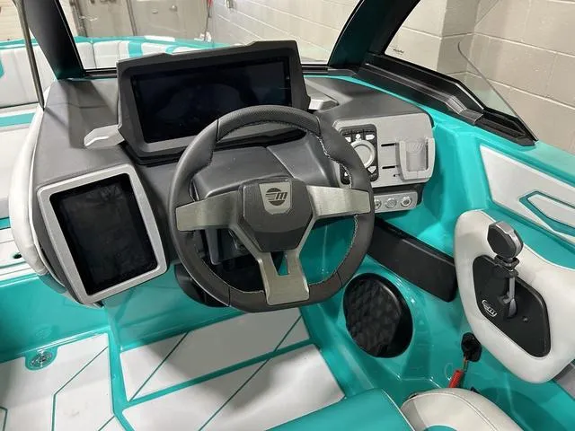 Slide: The Image of 2023 Malibu 21 LX boat dashboard with modern controls and teal accents. - 16